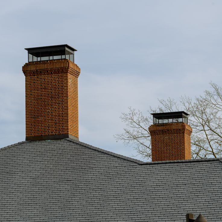 Brick chimney stack on modern contemporary house roof top modern pipe
