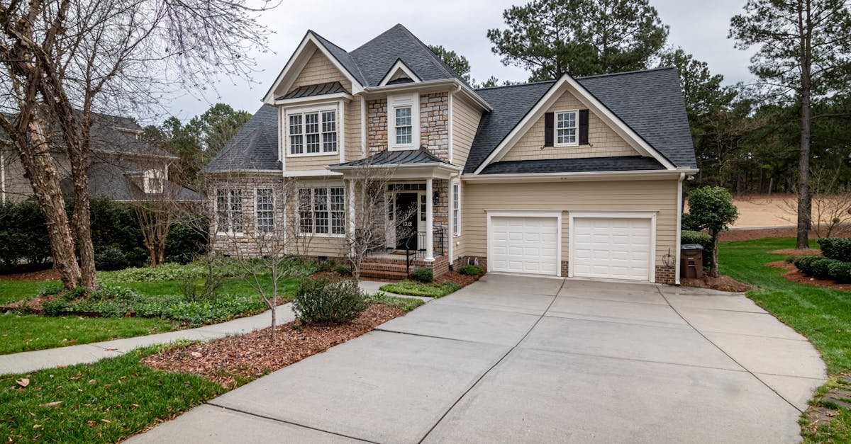 Charming suburban home featuring a two-car garage, manicured lawn, and inviting entrance.